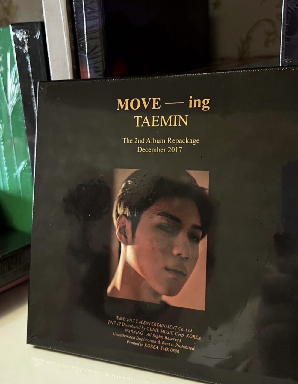 Альбом-репакет MOVE-ing Тхеміна (SHINee) у темній обкладинці з портретом артиста та золотим написом.